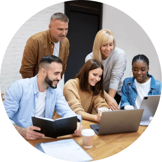 a group of people looking at a laptop